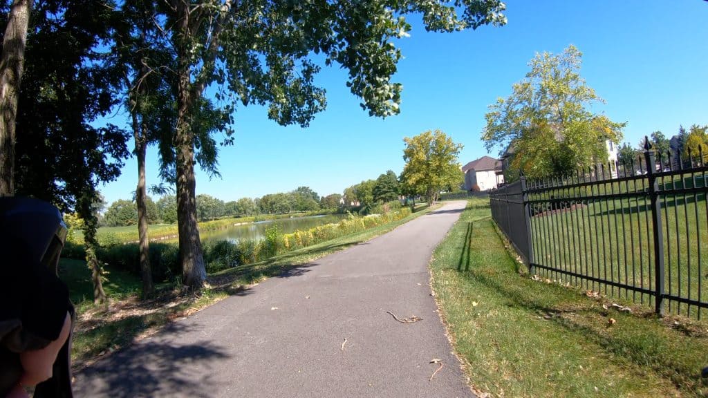Quiet suburban bike path with scenic lake views and lush greenery, perfect for leisurely cycling and outdoor recreation.