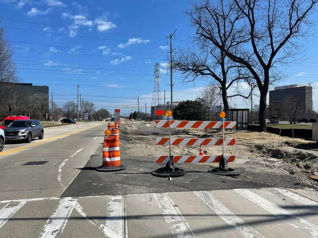 Construction zone on a wide street in a suburban industrial and retail area.