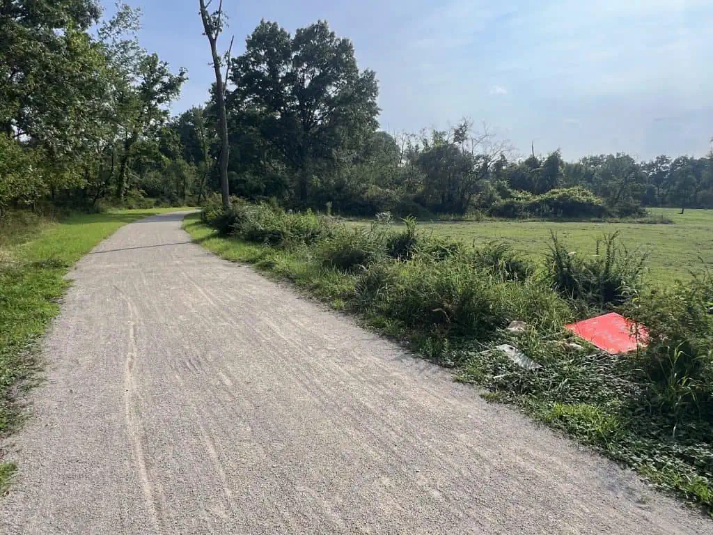 Scenic rural bike path winding through green fields and trees in suburban Chicago.